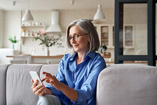 Lady sitting on couch using a mobile phone