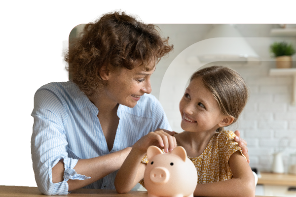 Woman and young girl putting coin into a piggybank